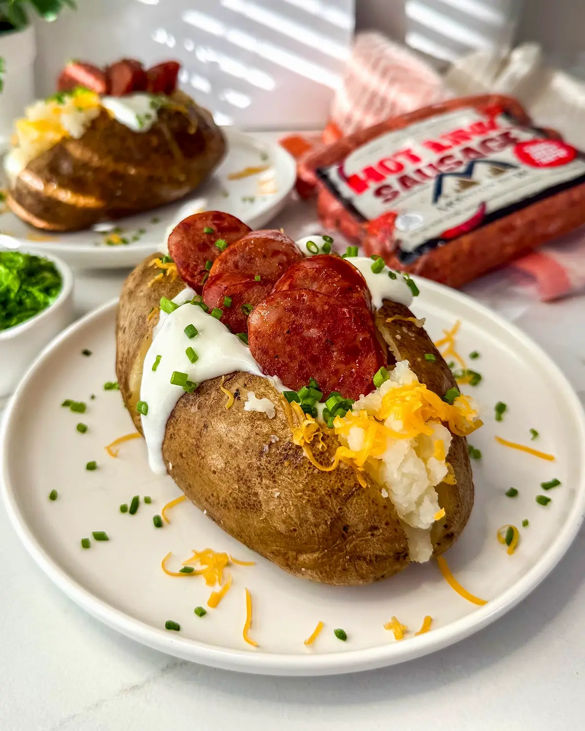 A loaded baked potato topped with cheese, butter, sour cream, chives, and Mountain View hot links